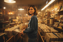 Load image into Gallery viewer, Model wearing the Jerry Lee Lewis 1972 Wembley sweatshirt in a vintage record shop